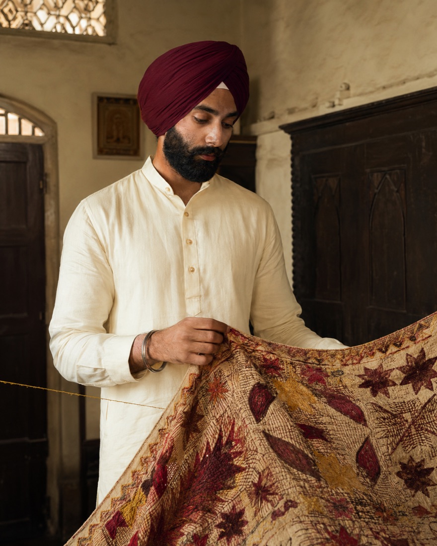 ਲਾੜਾ, ਸੂਈ ਅਤੇ ਧਾਗੇ ਨਾਲ ਕੱਪੜਾ ਫੜੀ